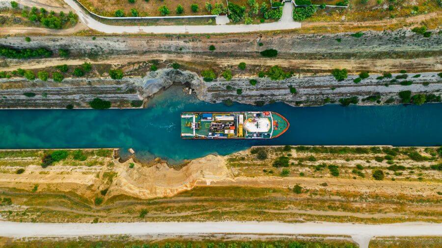 A colorful barge floats down a narrow river, symbolizing the potential for bank loans to float to a narrow outcome