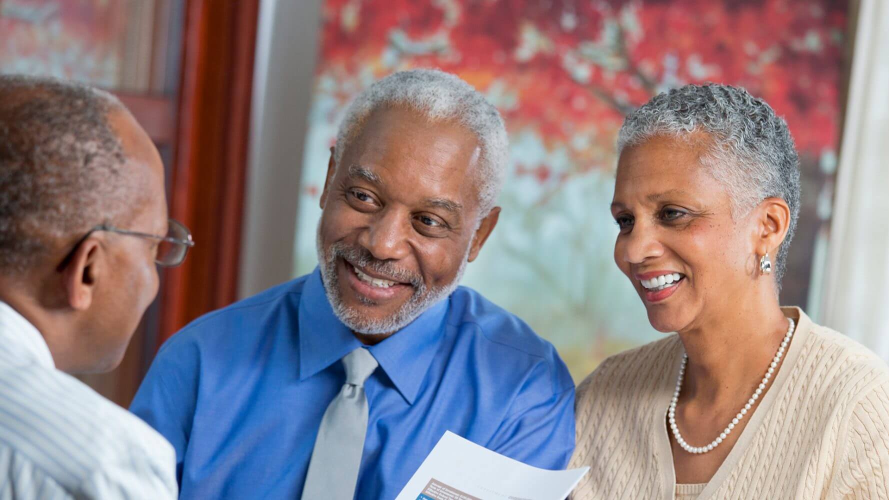 Elderly couple speaks to their financial advisor about their finances, client loyalty