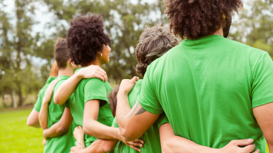 A group of people stand in matching green T-shirts, ESG Investing