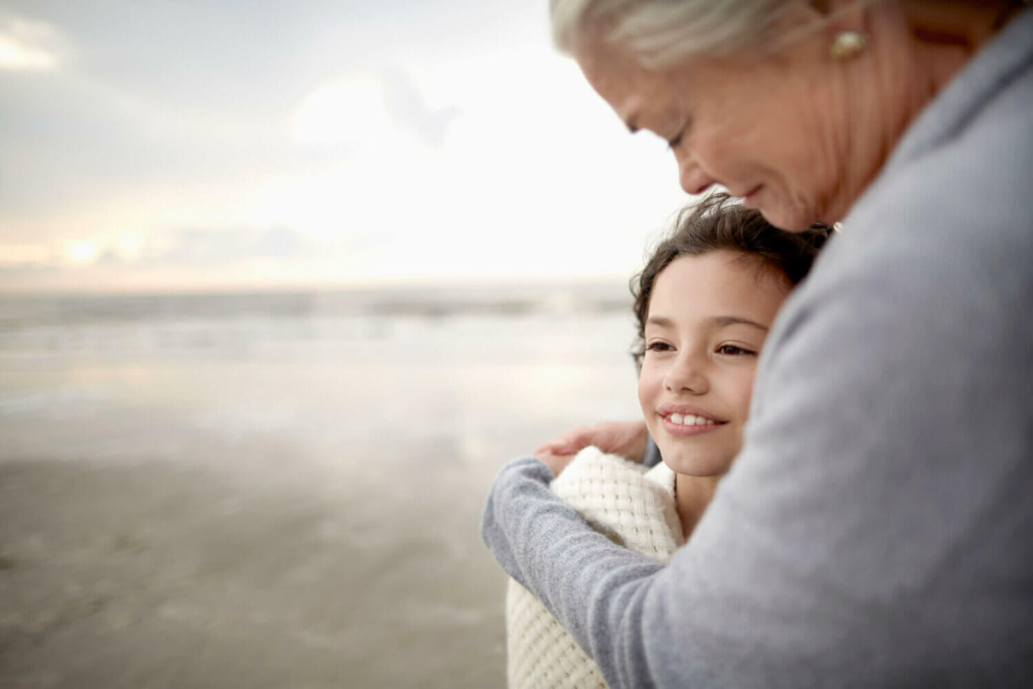 A woman looks down at her granddaughter, happy to have utilized successful family wealth planning.