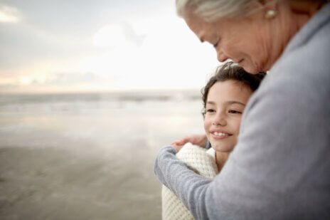 A woman looks down at her granddaughter, happy to have utilized successful family wealth planning.