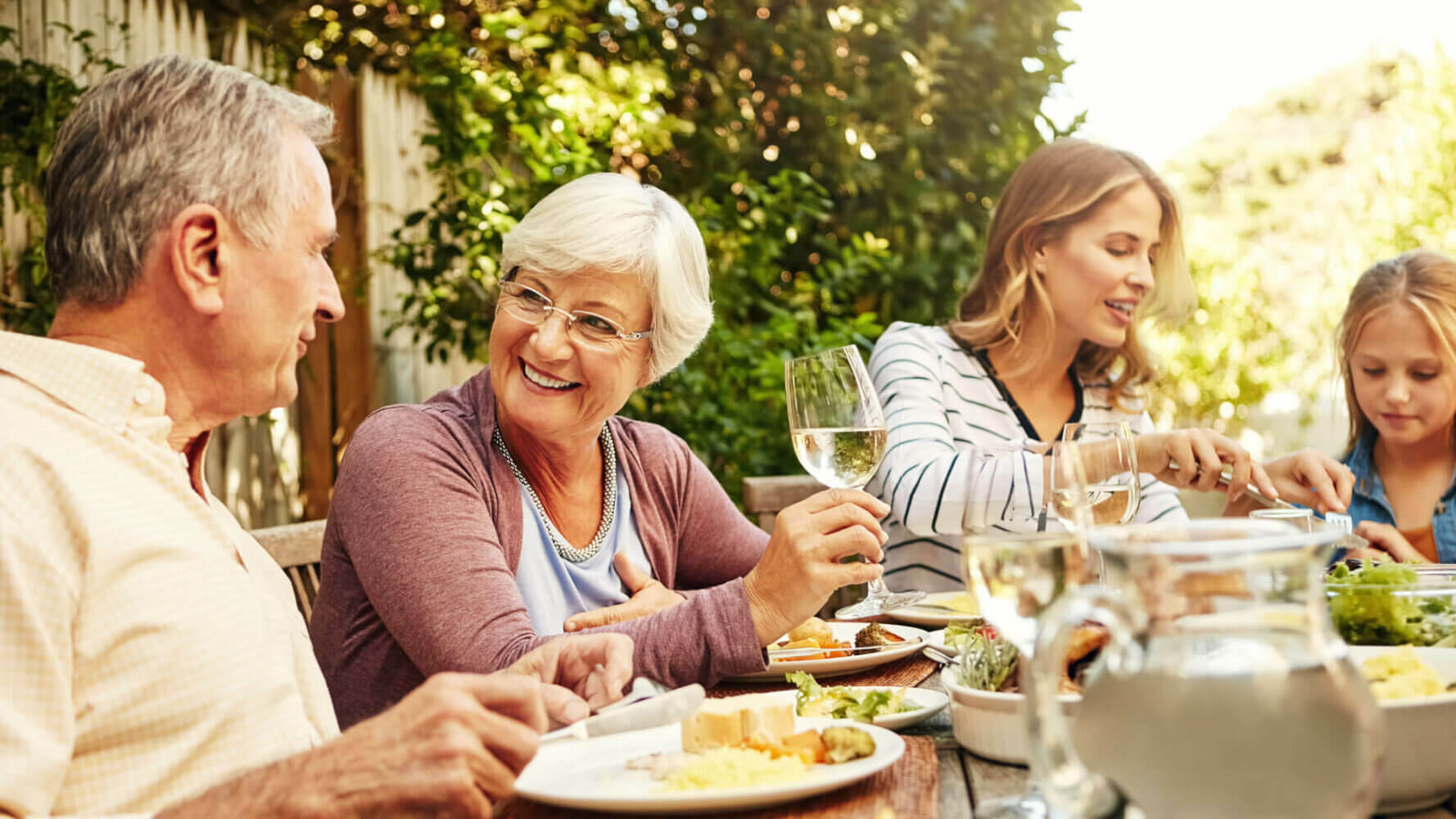 Giving clients the gift of generations as three generations of people in a family sit at a dinner table enjoying a meal together.
