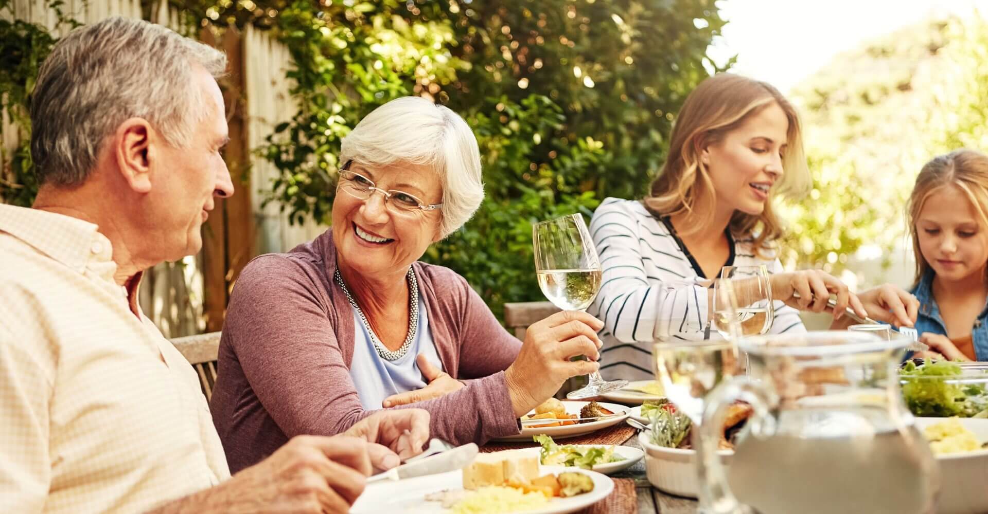Giving clients the gift of generations as three generations of people in a family sit at a dinner table enjoying a meal together.