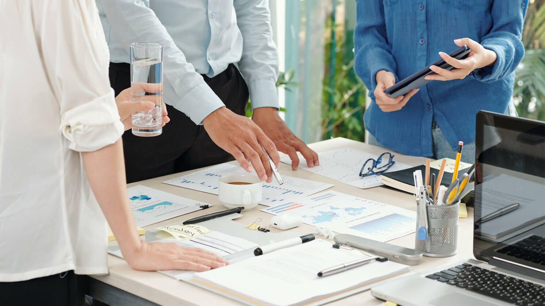 Intrinsic value of risk, group of coworkers stands around pile of paperwork and discusses the risk associated with the project