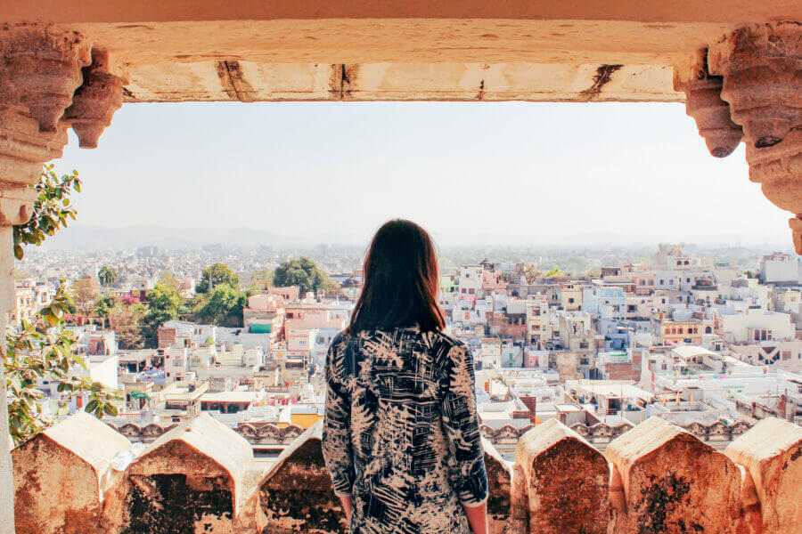 A young woman looks out over the city of Udaipur, Rajasthan, North India.