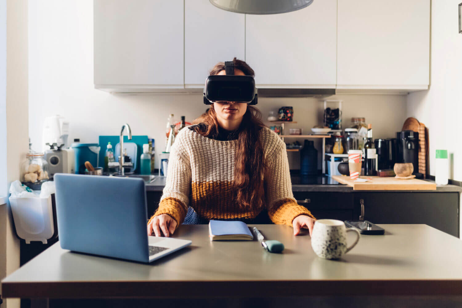 Woman with virtual reality headset sitting at desk at home