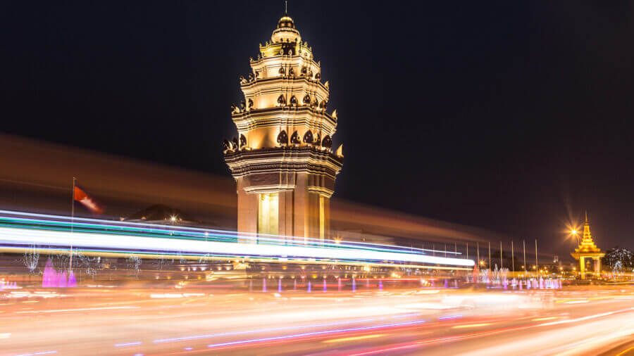 Traffic, captured with blurred motion, rush in front of the Independance monument at night in the heart of Phnom Penh at night in Cambodia capital city