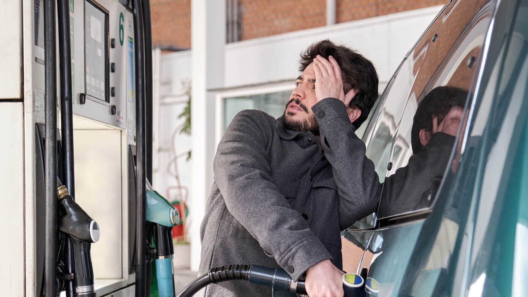 Man looks shocked as he notices the prevalence of inflation in high gas prices.