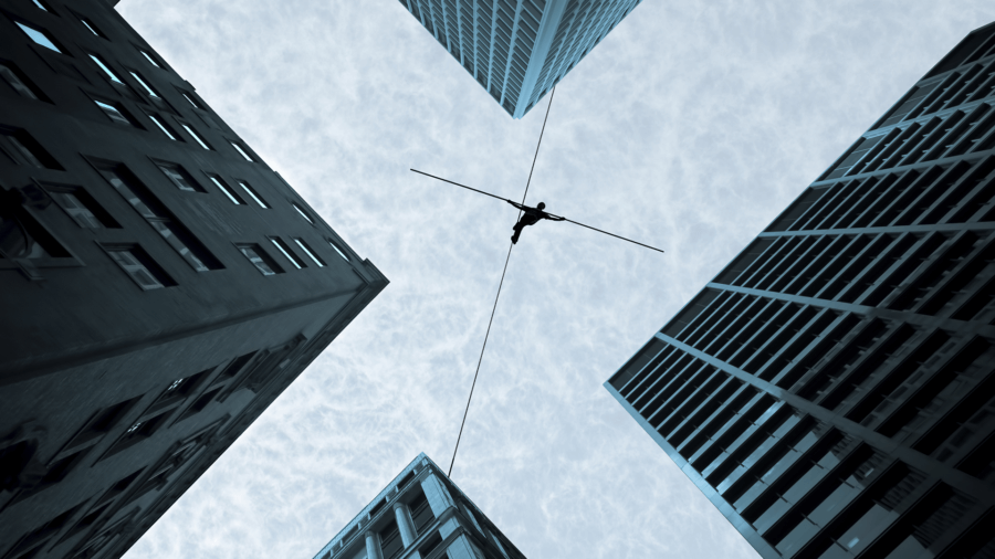 Dream, plan, and achieve no matter the height, wire walker crosses high rise buildings.