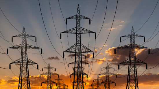 High voltage towers at sunset background. Power lines against the sky