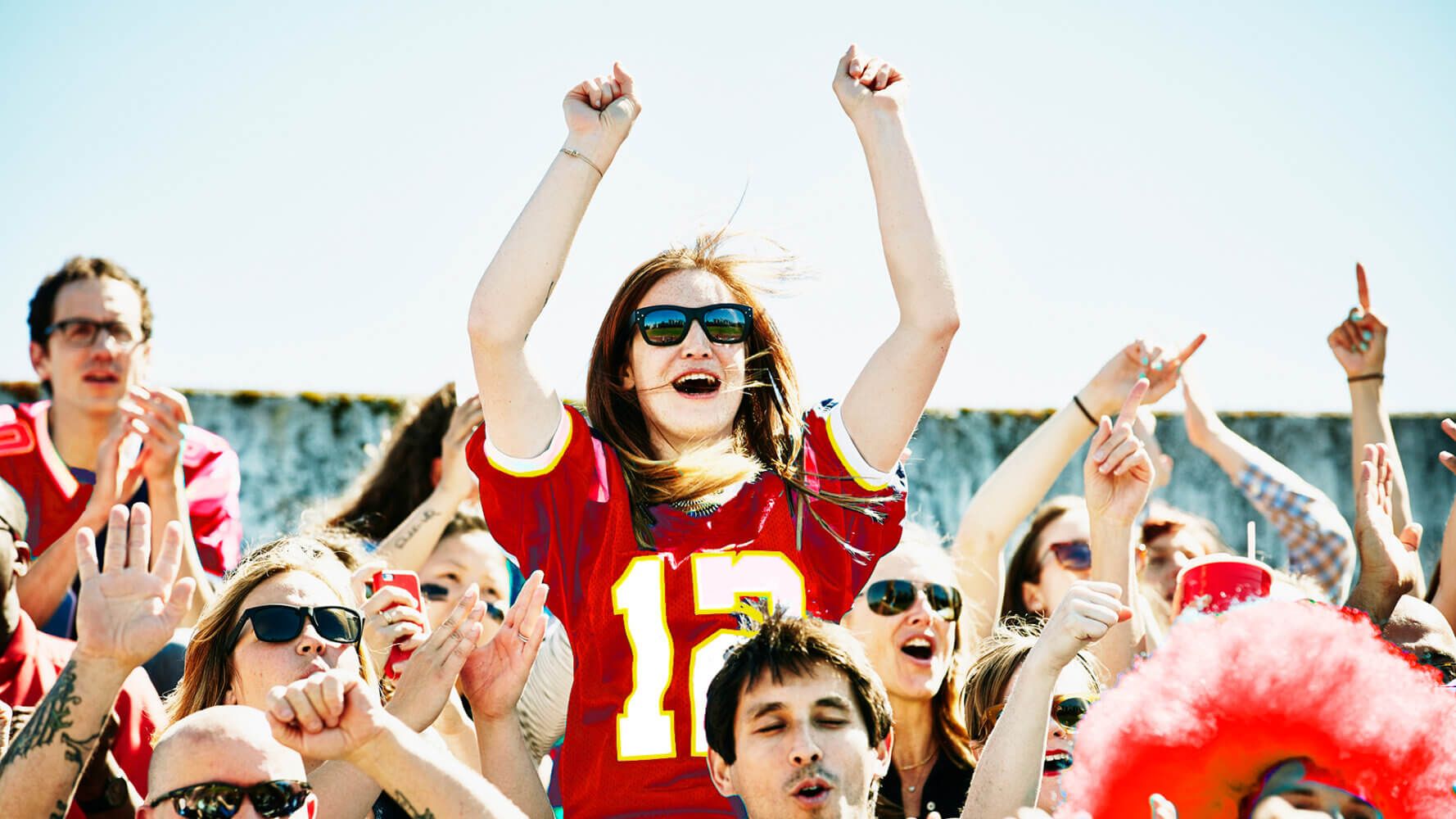 Women cheering with jerseys on in a crowd