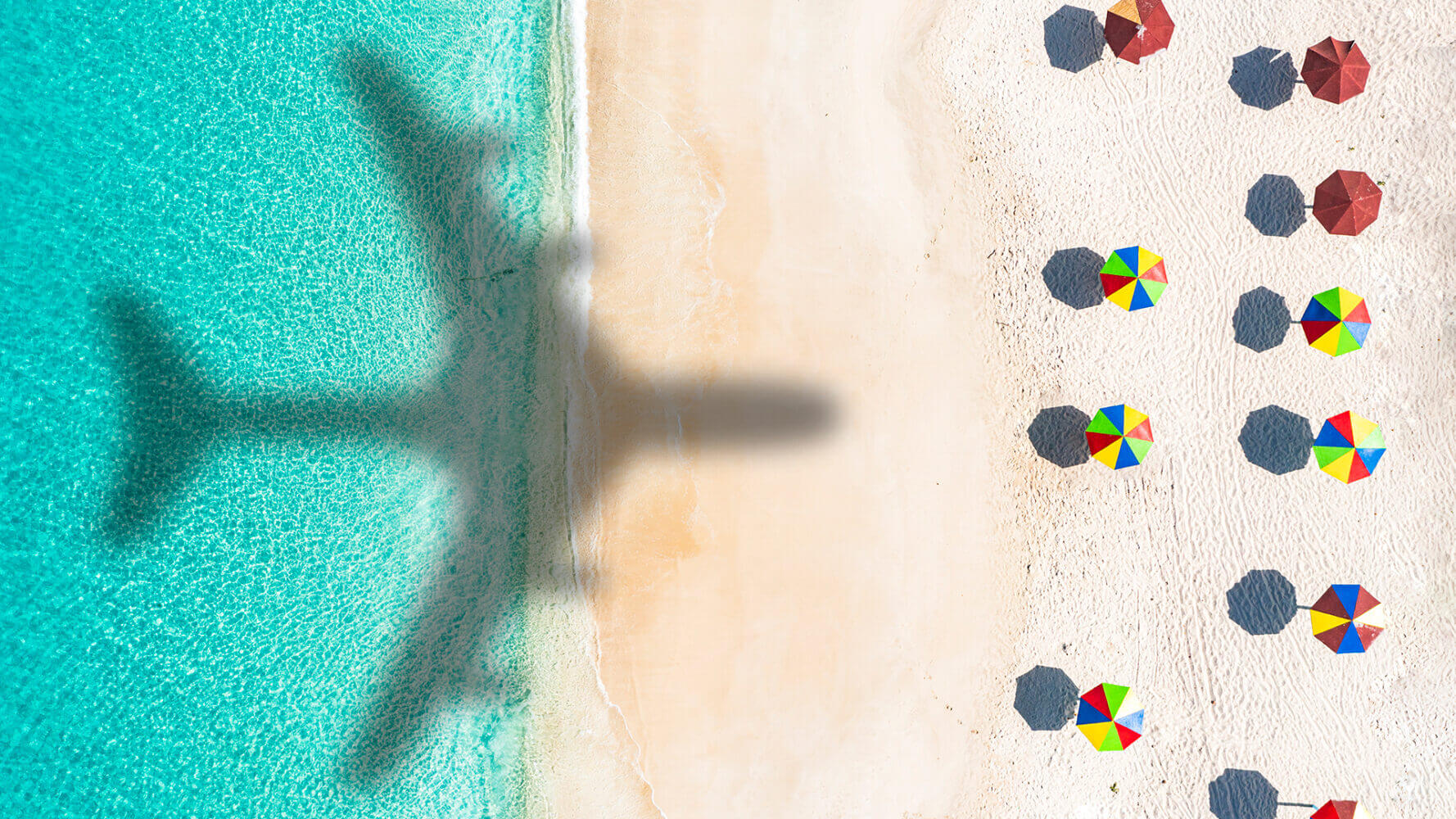 Aerial view of silhouette of airplane flying over idyllic tropical beach, Antigua, Caribbean, West Indies