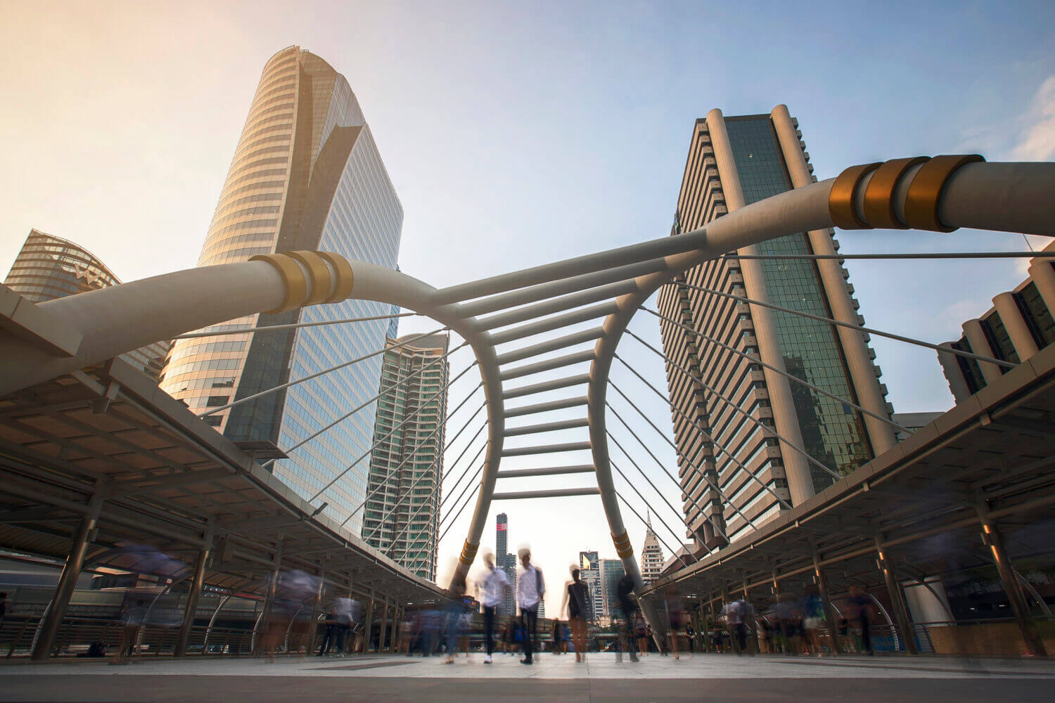 People, captured with blurred motion, walk in front of modern corporate office towers in the heart of Bangkok business district in Sathorn and Silom. Bangkok,Thailand