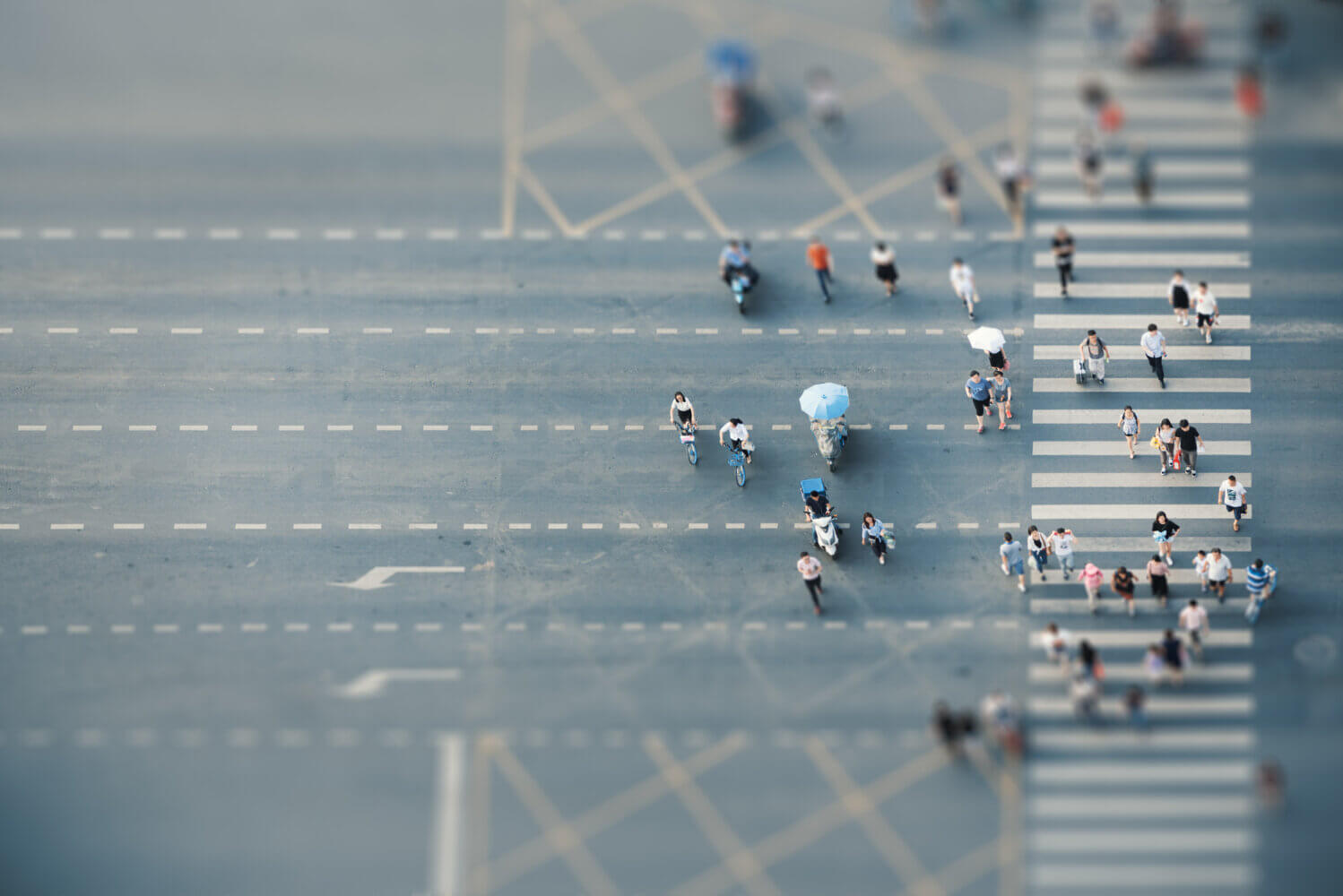 People crossing a road on zebras aerial top view with tilt-shift effect in Chengdu, China