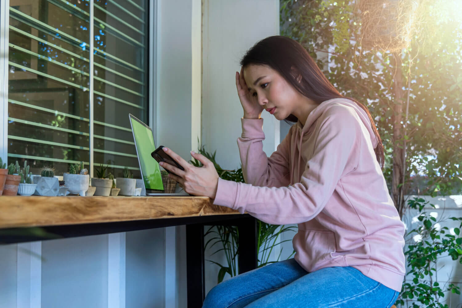 Fears of recession create worry for a young woman sitting by her computer.