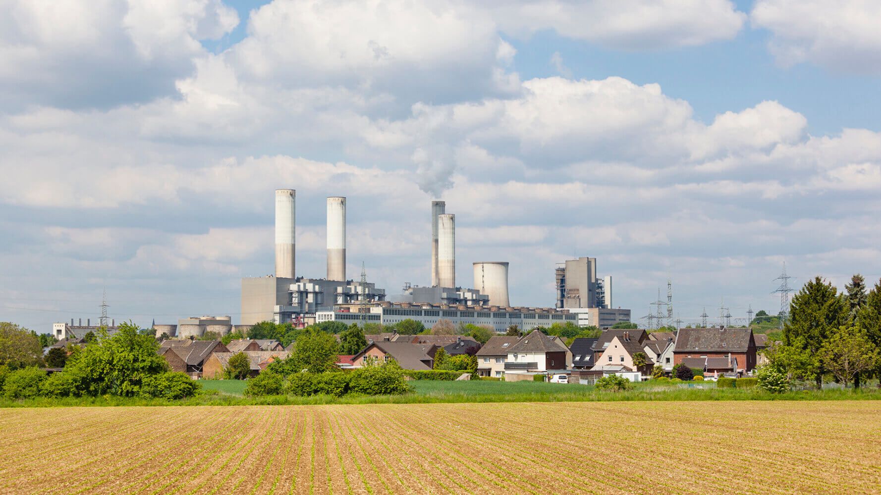 A decommissioned lignite power station behind a village