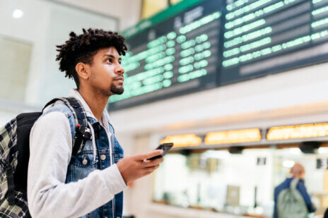 Young man checks his airline status against his mobile ticket.