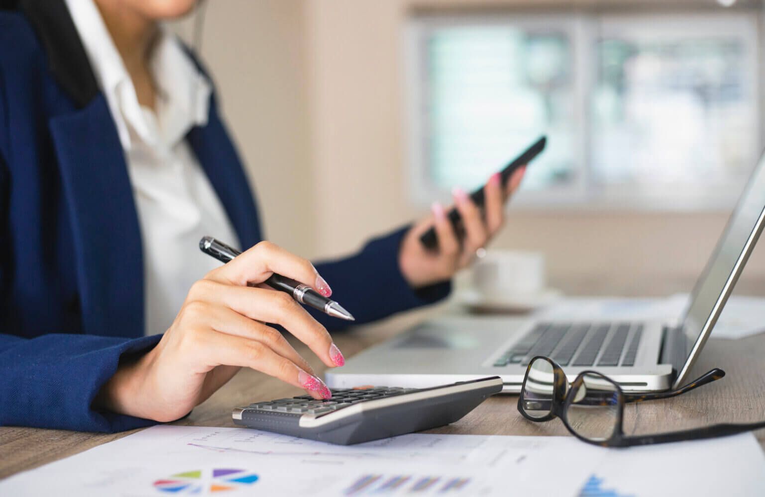 Woman calculates some financial decisions over her desk.