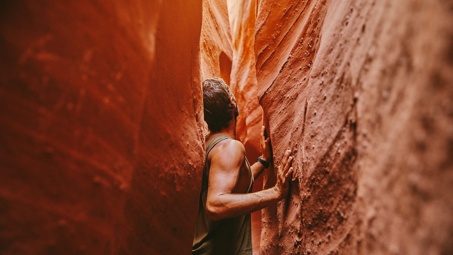Young man exploring narrow slot canyons in Escalante, during summer